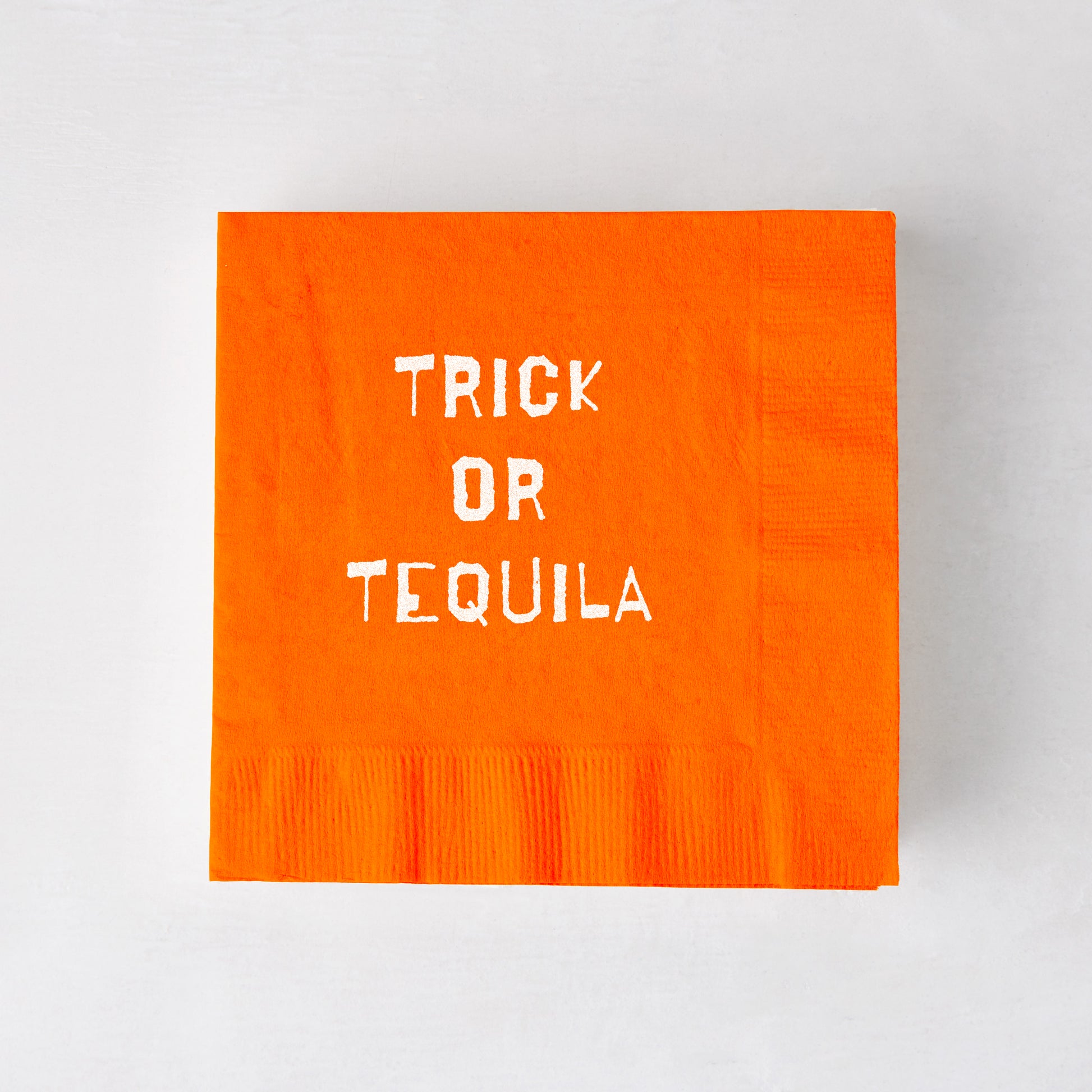 Square orange 3-ply paper cocktail napkin with white Trick or Tequila text, 5.5 inches.