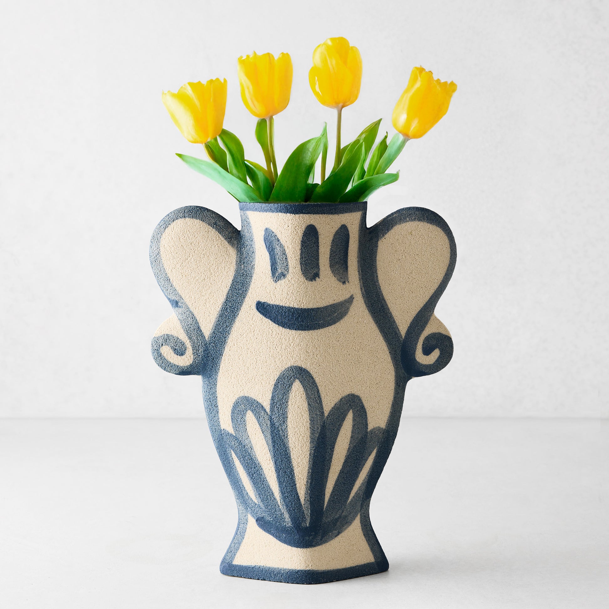 Trompe-L'oeil Floral N2 Krater stoneware vase with blue hand-painted Greek-inspired details and yellow tulips.