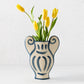 Trompe-L'oeil N1 Krater stoneware vase, 12.6"H, with raw texture and hand-painted blue Greek-inspired detailing, holding yellow tulips.