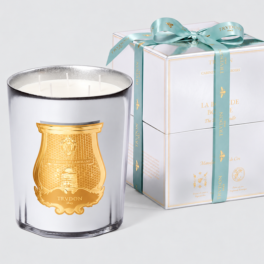 Trudon five-wick candle in a mirrored celadon glass with a gold emblem, next to a matching gift box with a teal ribbon.