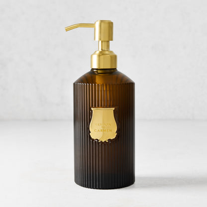Trudon Carmen liquid hand soap in a ribbed amber glass bottle with a gold pump and label.