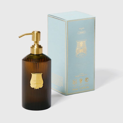 Trudon Carmen liquid hand soap in a ribbed dark amber glass bottle with a gold pump and label, beside a light blue box.