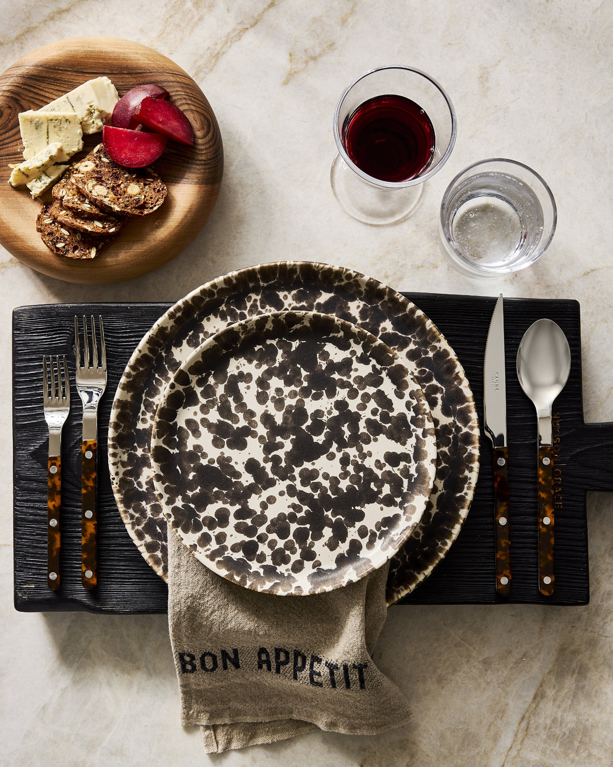 Hudson Grace Nuno splatter dinnerware styled with tortoise flatware and a linen napkin