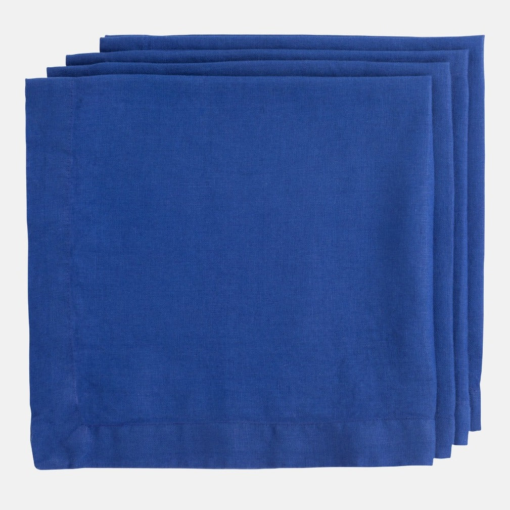 Stack of three Ultramarine HG Signature hand-dyed 22" square linen napkins with mitered corners.
