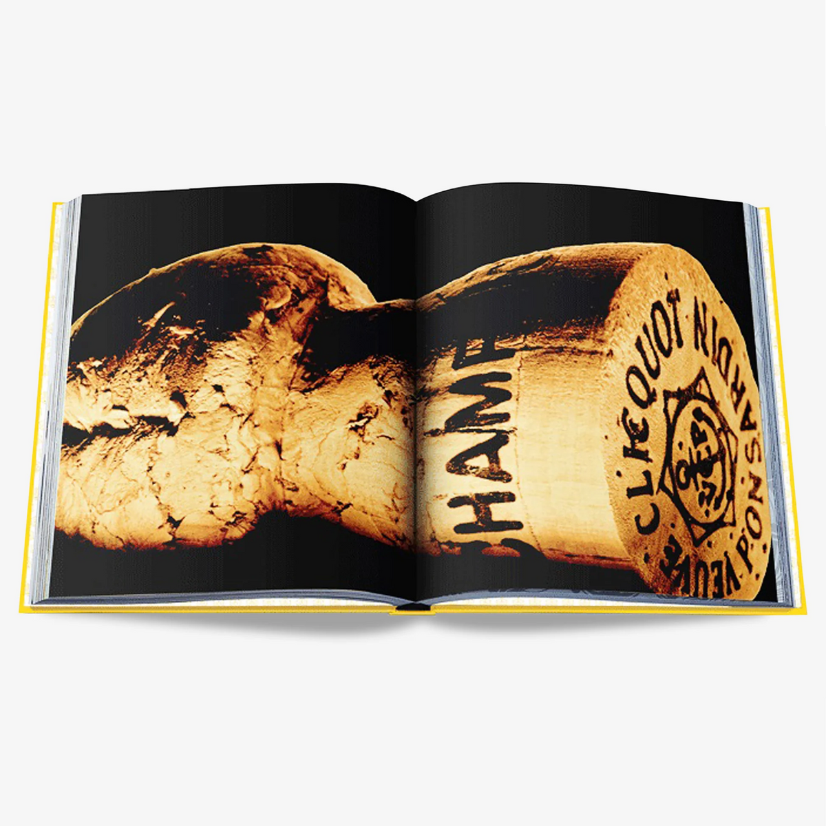 Open Veuve Clicquot book with yellow spine, showing a close-up of a champagne cork on black pages.