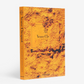 Orange hardcover "Veuve Clicquot" Assouline book with textured cover and gold lettering.