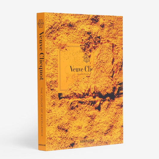 Orange hardcover "Veuve Clicquot" Assouline book with textured cover and gold lettering.