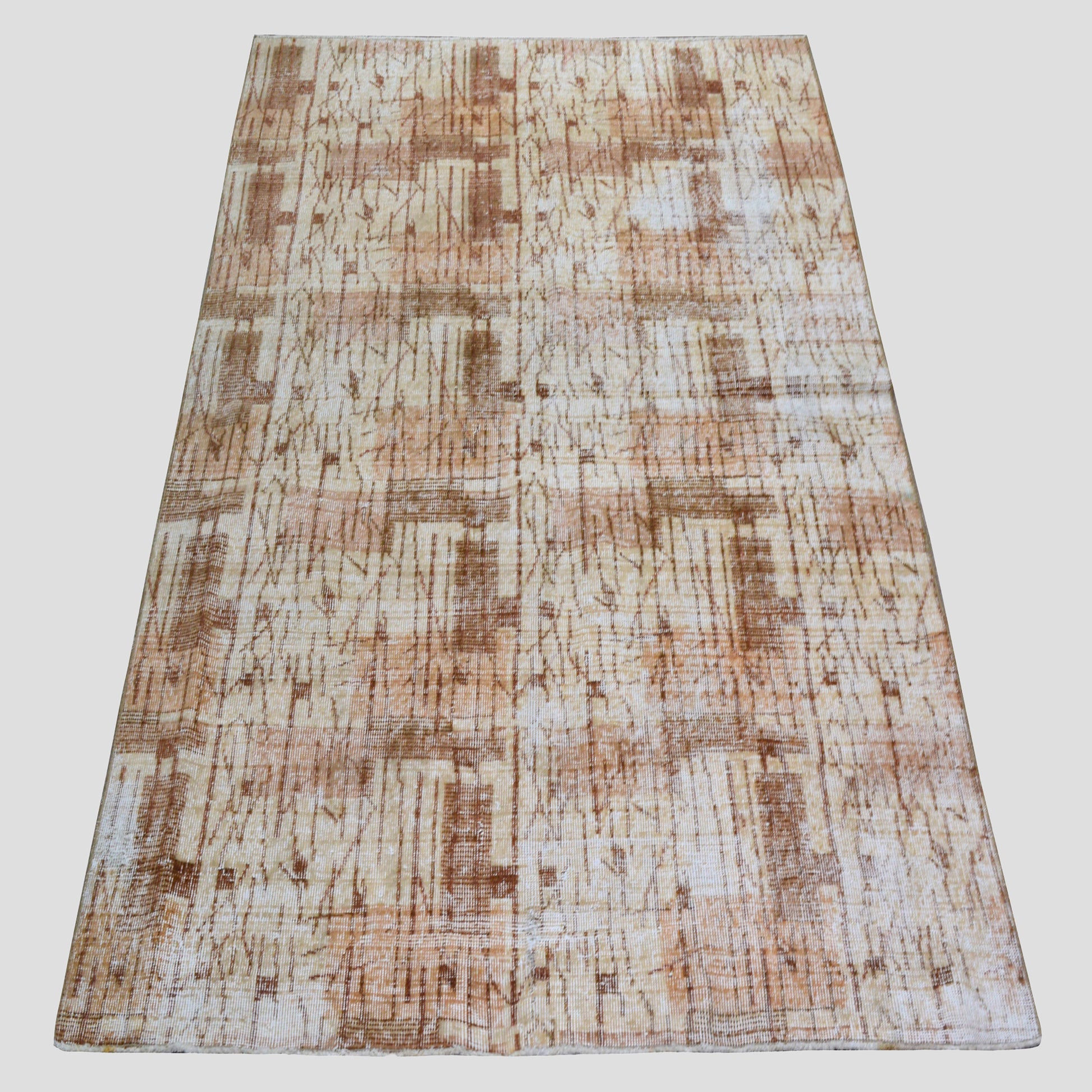 Vintage 4'9"x7' brown patterned Turkish wool rug with natural fading and low pile.
