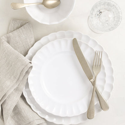 Vintage Champagne 5-piece flatware set with neo-baroque design, warm silvery-champagne finish, on white scalloped plates.
