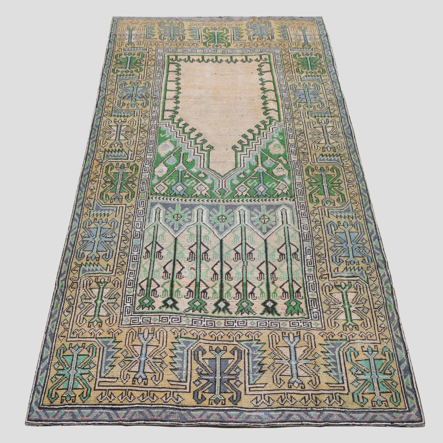 Vintage 4'7"x9' Turkish wool rug with cream base, green, blue, and yellow geometric patterns.
