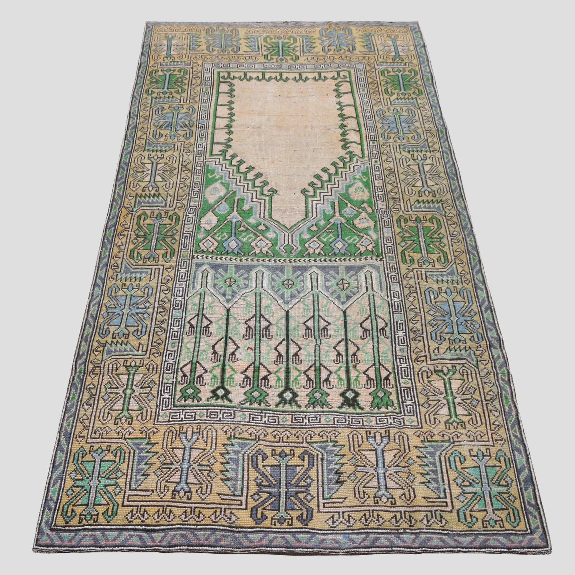 Vintage 4'7"x9' Turkish wool rug with cream base, green, blue, and yellow geometric patterns.