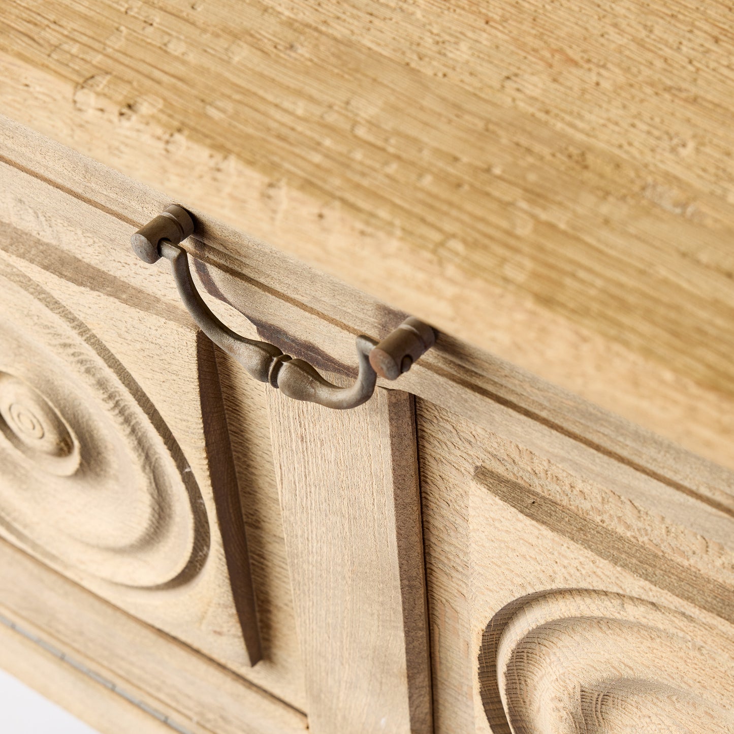 Bleached oak bar console with carved circular door patterns and a vintage brass drop pull handle.