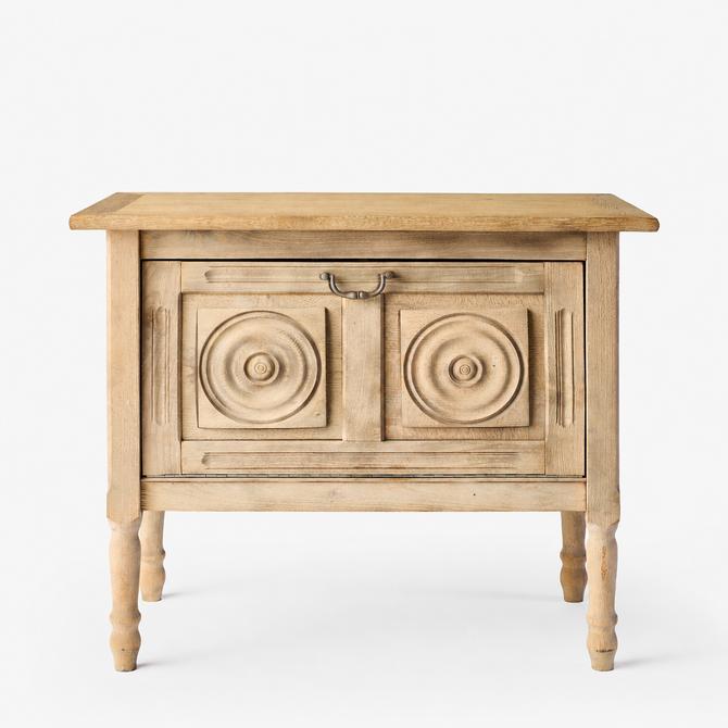 Vintage bleached oak bar console with carved circular door panels and a brass drop pull handle on turned legs.