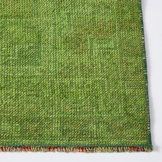 Vintage green wool rug, 3'10 x 6'8, featuring a low-pile, handcrafted texture with natural color variations.