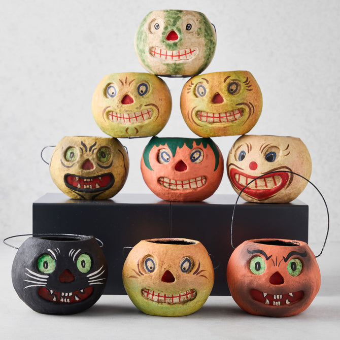 Set of nine vintage-style papier-mâché Halloween candy buckets with distressed, hand-painted jack-o'-lantern faces.
