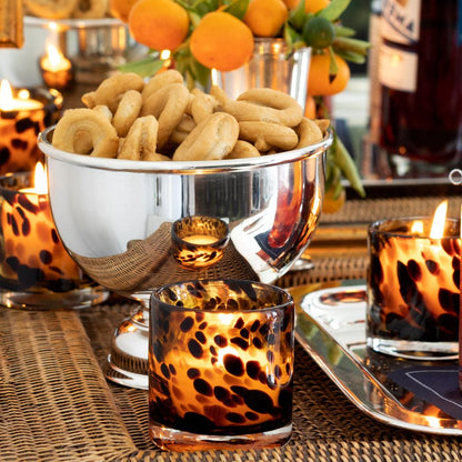 Vintage silverplate 6'' footed bowl filled with snacks, surrounded by leopard print votives and oranges.