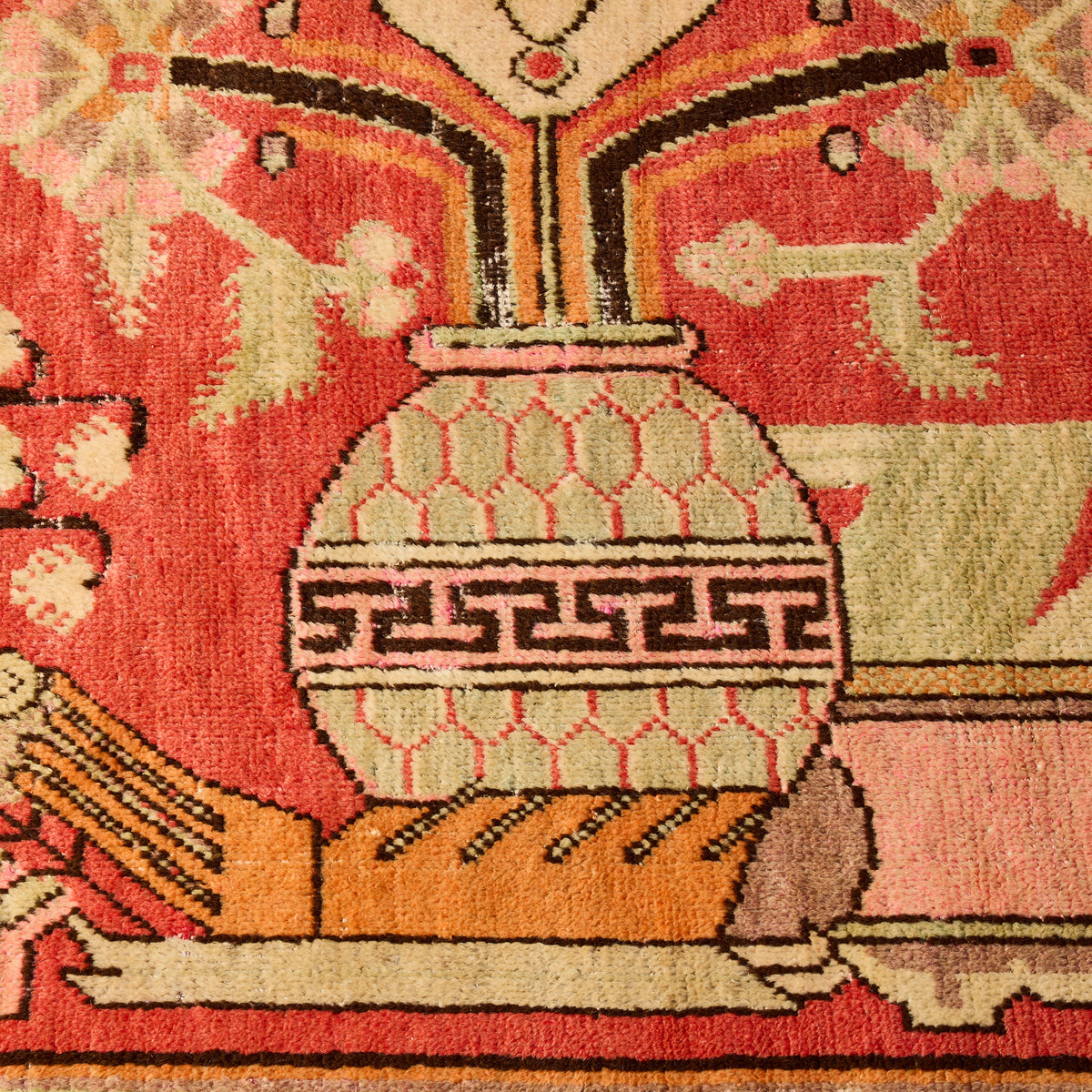 Vintage Khotan wool rug featuring a multicolor floral vase pattern with faded red, orange, and green tones.
