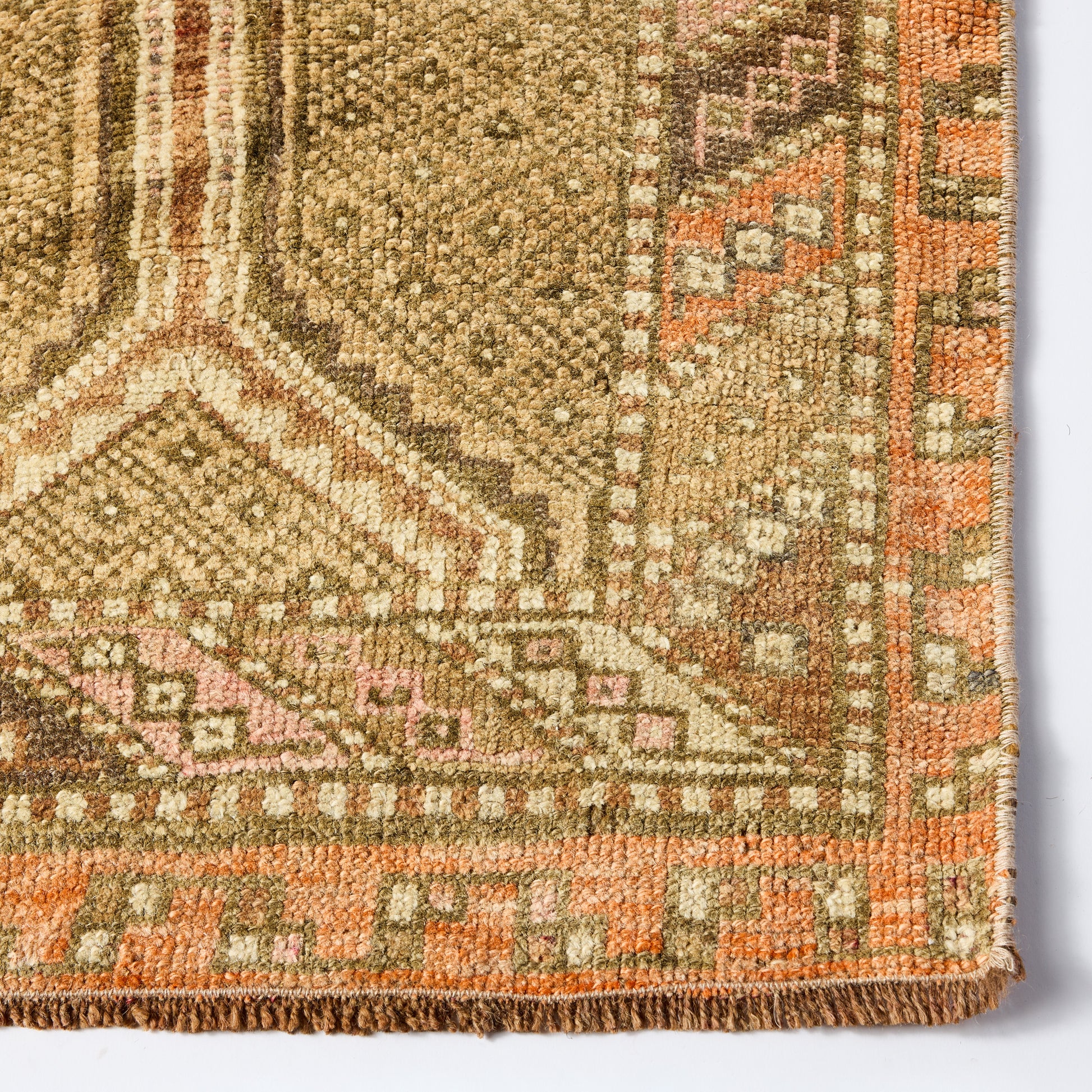 Vintage Linnea wool runner rug in faded brown and orange with a low-pile, handcrafted geometric pattern.