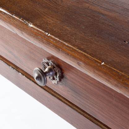 Vintage mahogany kitchen table drawer with a detailed metal handle and aged wood grain texture.
