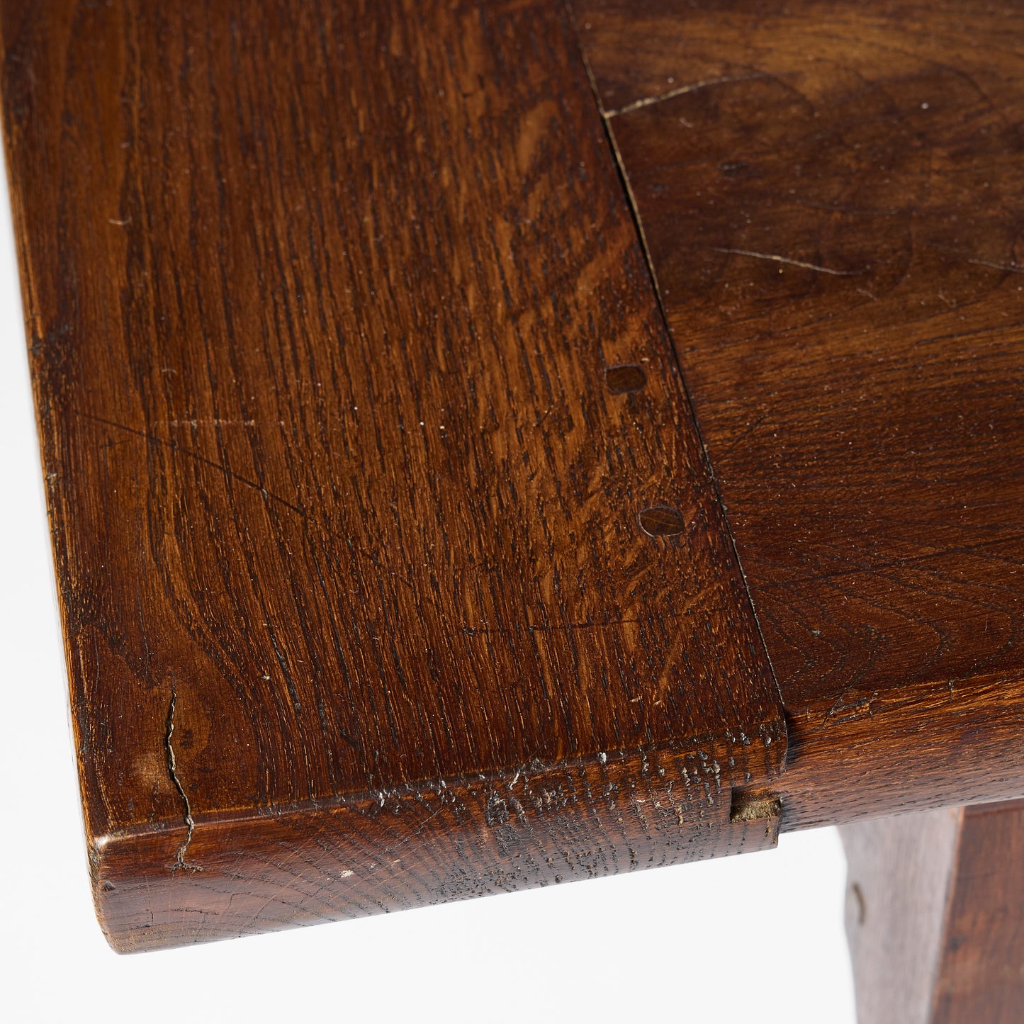 Close-up of a vintage mahogany kitchen table surface showing aged wood grain, natural textures, and joinery details.