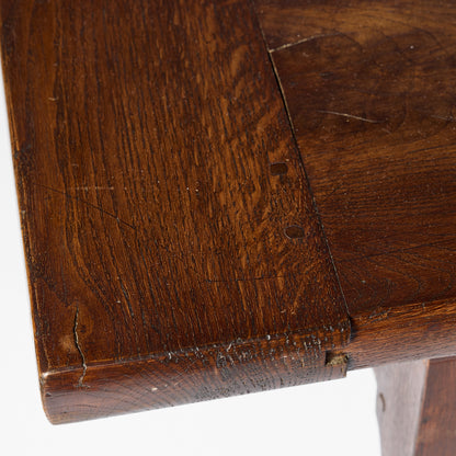Close-up of a vintage mahogany kitchen table surface showing aged wood grain, natural textures, and joinery details.