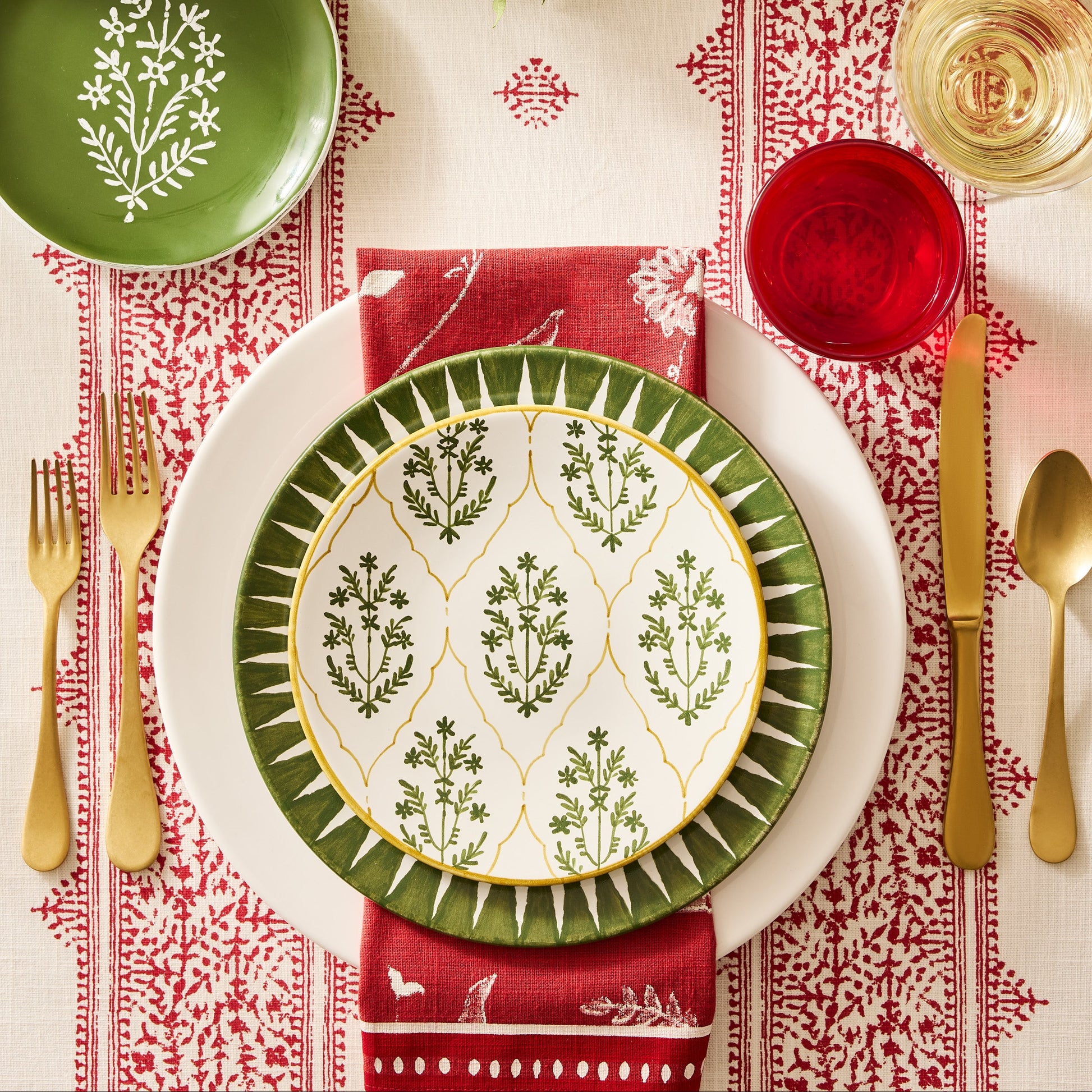 Vintage Oro gold stainless steel 5-piece flatware set with a matte finish arranged on a festive holiday table setting.