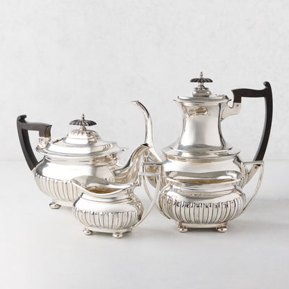 Vintage silverplate 4-piece tea set with ball feet, including teapot, coffee pot, creamer, and sugar bowl.