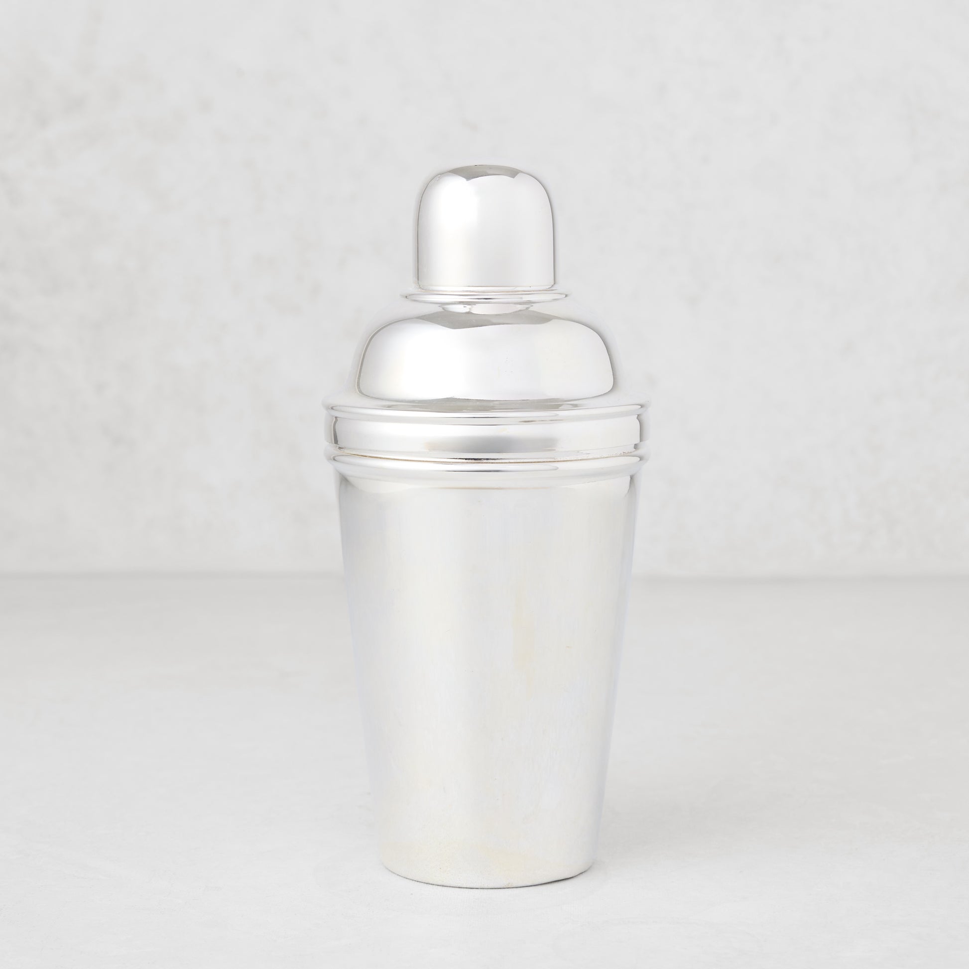 Vintage silverplate Estrella cocktail shaker, shiny, three-piece design.