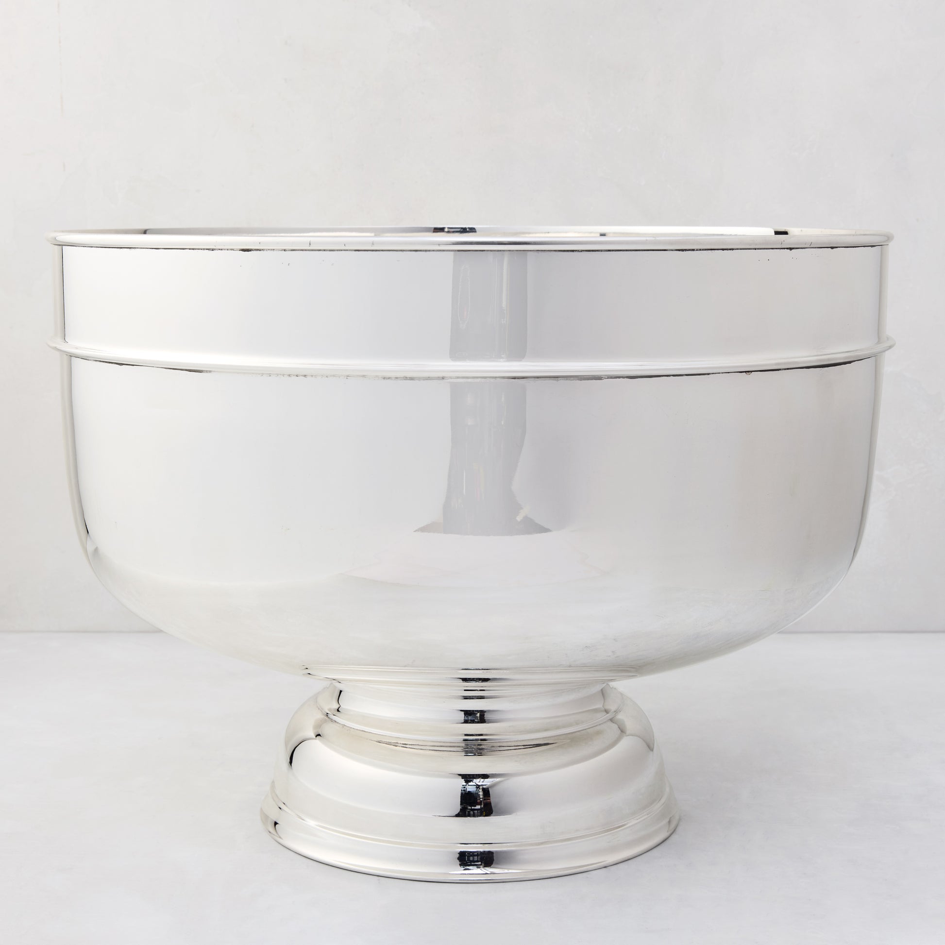 Vintage 18" silverplate footed grand punch bowl with a polished, reflective finish.
