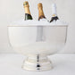 Vintage silverplate footed punch bowl, 14", filled with ice and three champagne bottles.