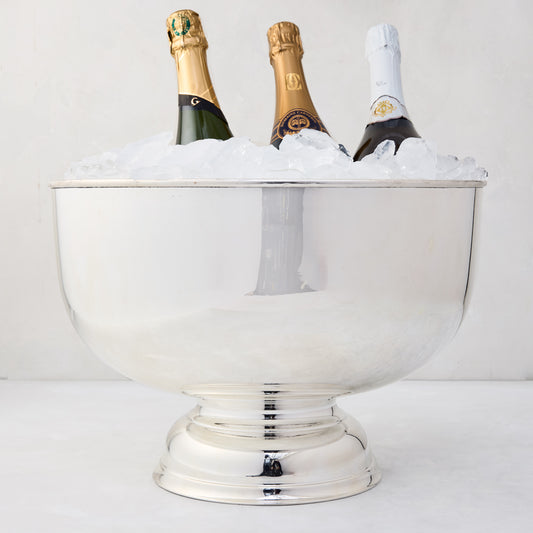 Vintage silverplate footed punch bowl, 14", filled with ice and three champagne bottles.