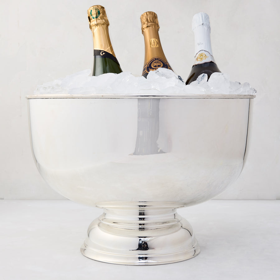 Vintage silverplate footed punch bowl, 14", filled with ice and three champagne bottles.