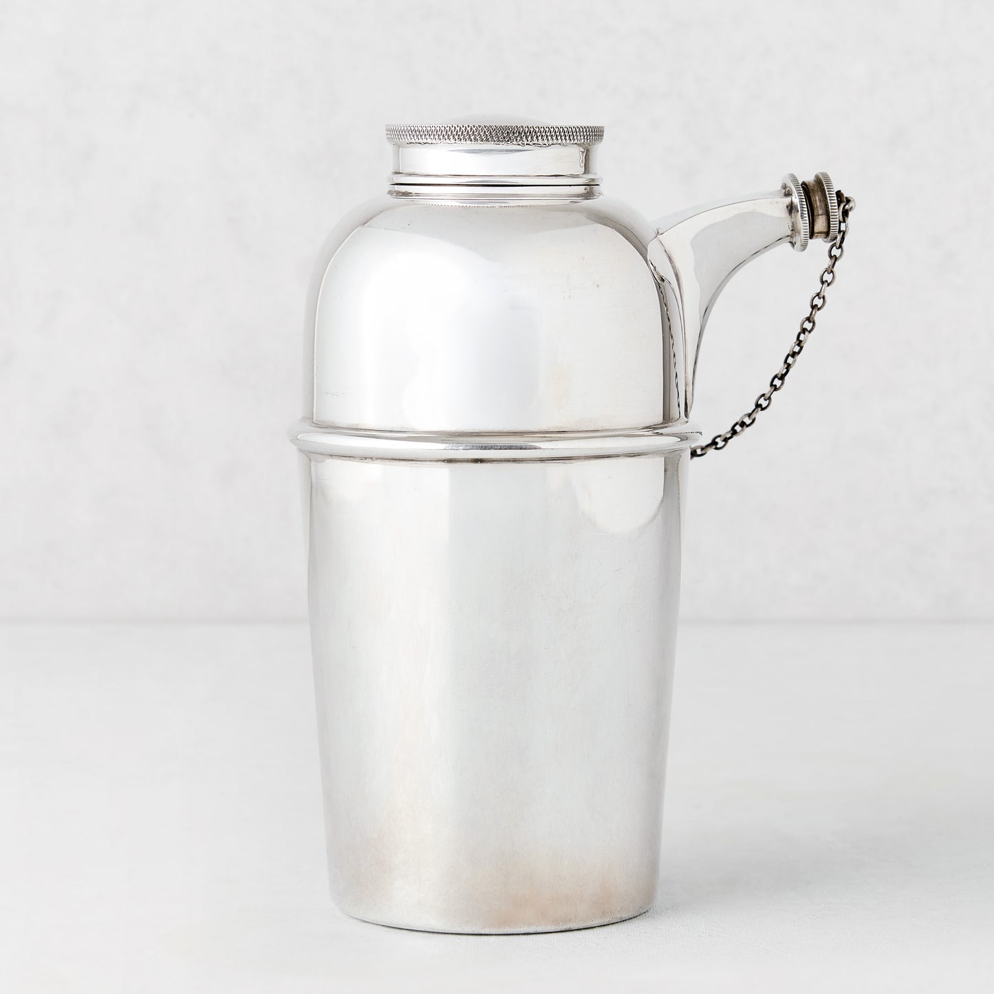 Vintage silverplate Gia shaker with spout and chain, sleek design.