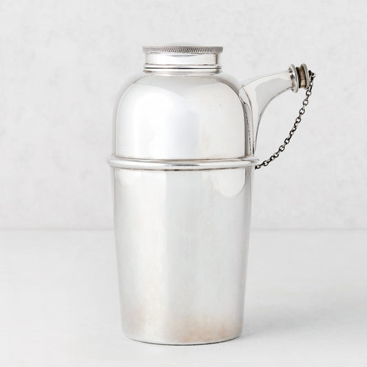 Vintage silverplate Gia shaker with spout and chain, sleek design.