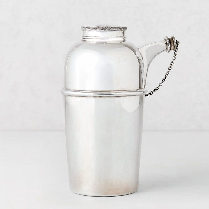 Vintage silverplate Gia shaker with spout and chain, sleek design.