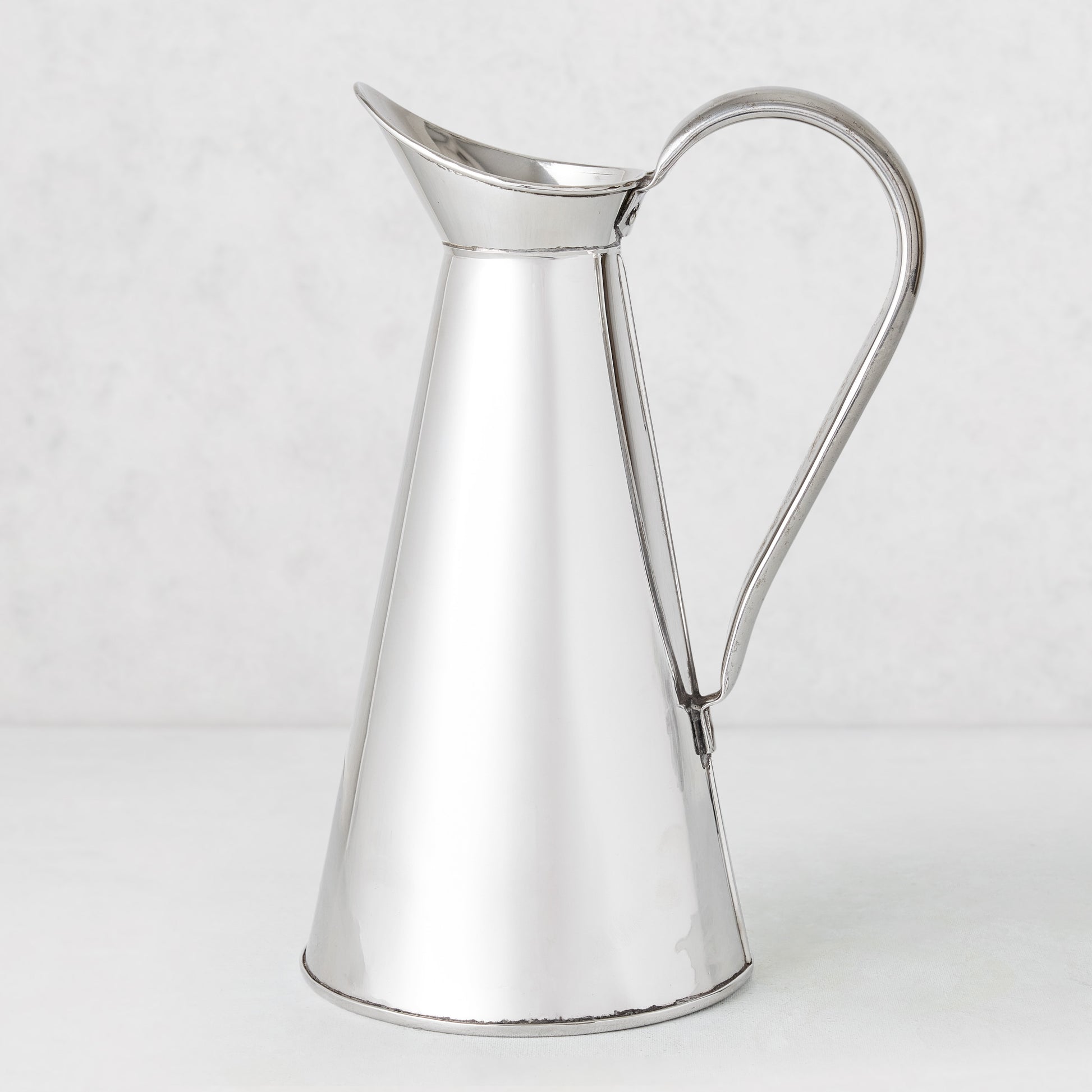 Vintage silverplate James pitcher, 11 inches tall, with a conical body and curved handle.