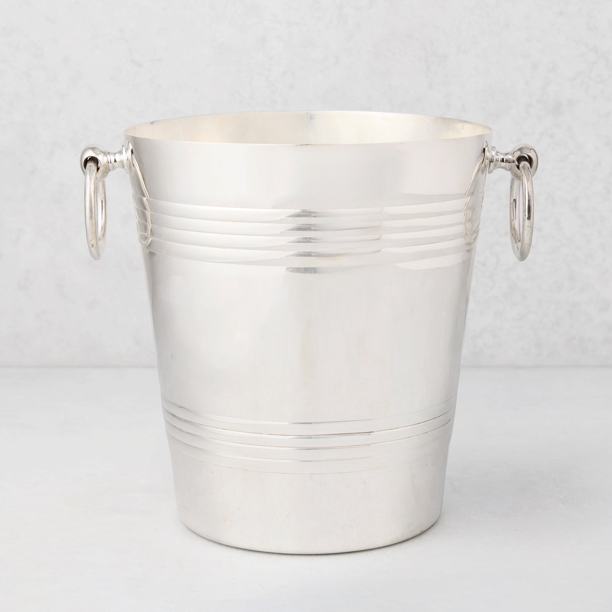 Vintage silverplate Mabel bottle holder, polished, with two ring handles and horizontal bands.