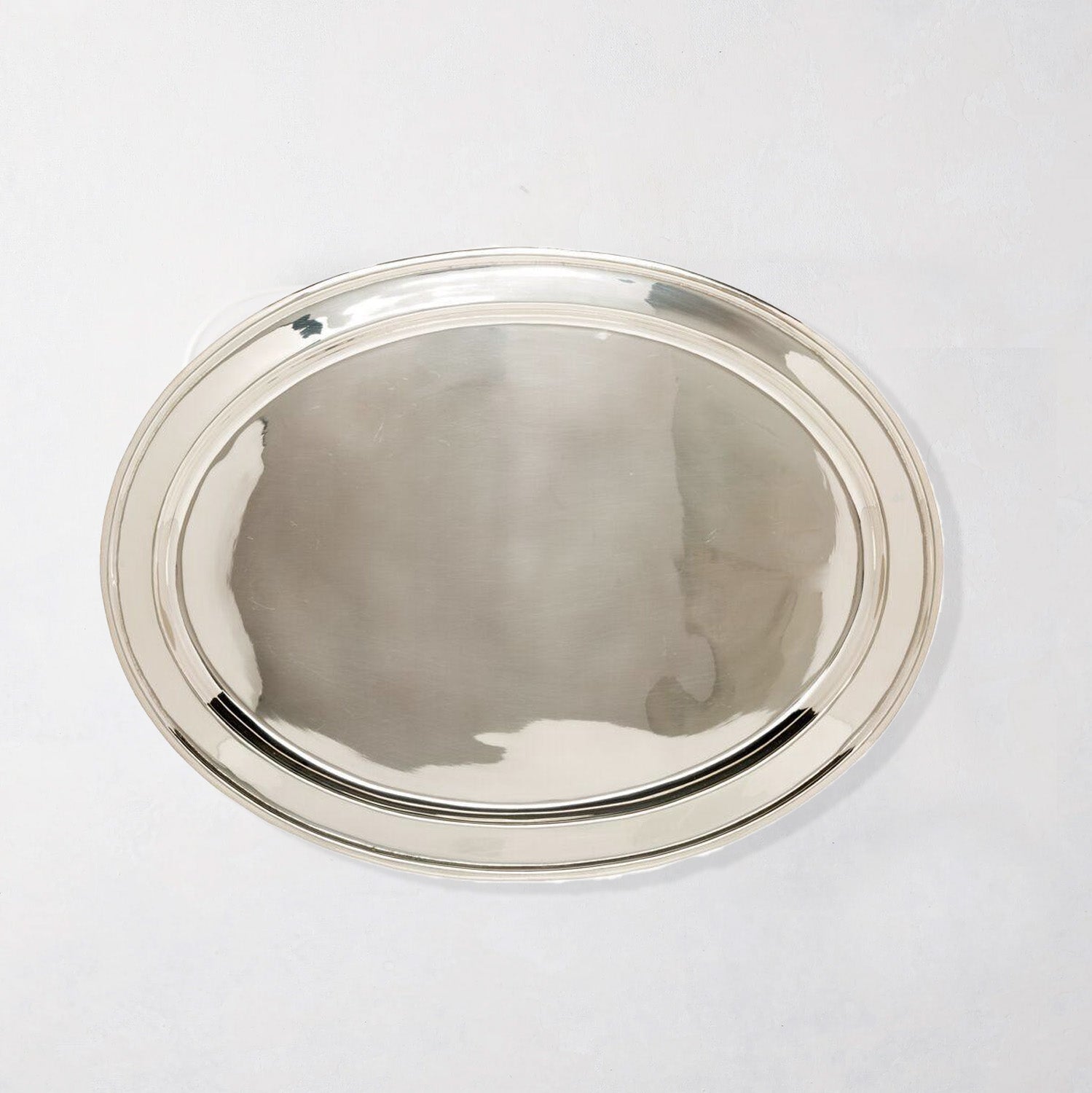 Vintage silverplate oval platter with a polished, reflective surface and simple double-rim design.