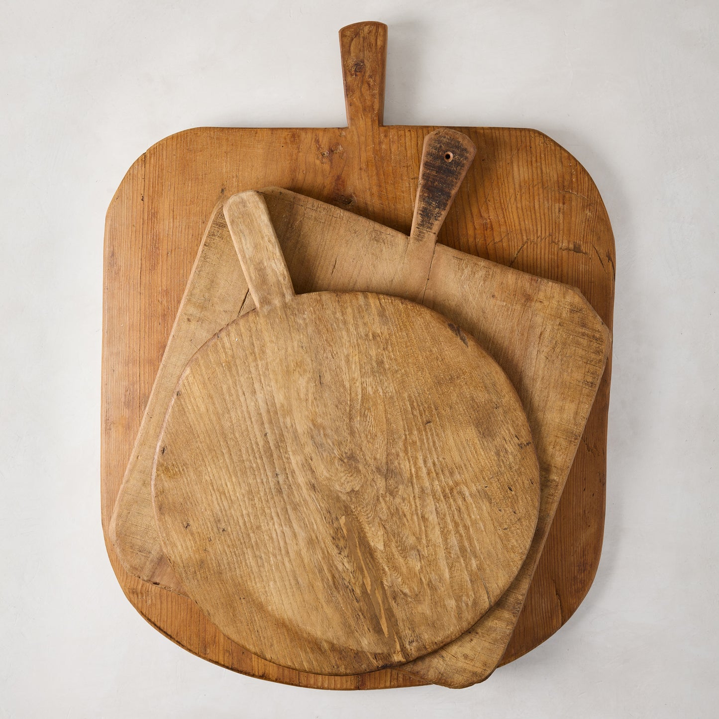 Three vintage reclaimed wood serving boards: large rectangular, medium square, and small round, with handles.