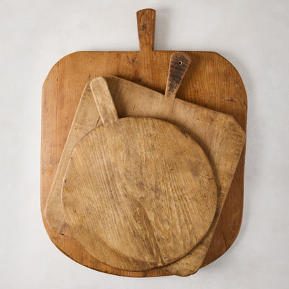 Three vintage reclaimed wood serving boards: large rectangular, medium square, and small round, with handles.