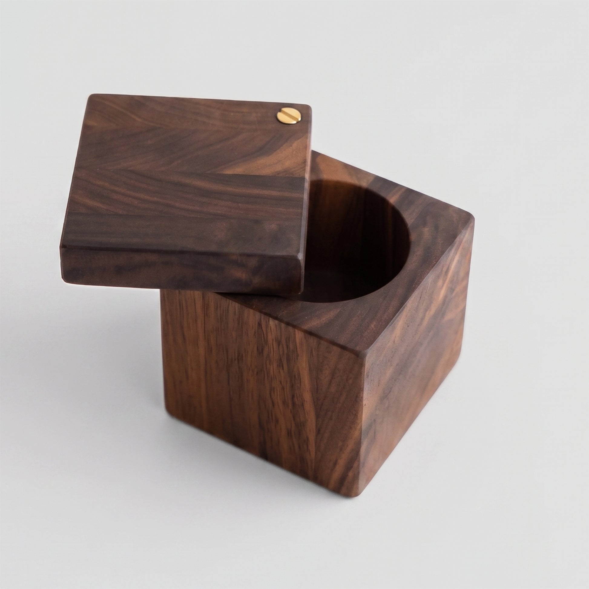 Handmade 3-inch square walnut wood salt cellar with a functional swivel lid and brass pivot on a white background.