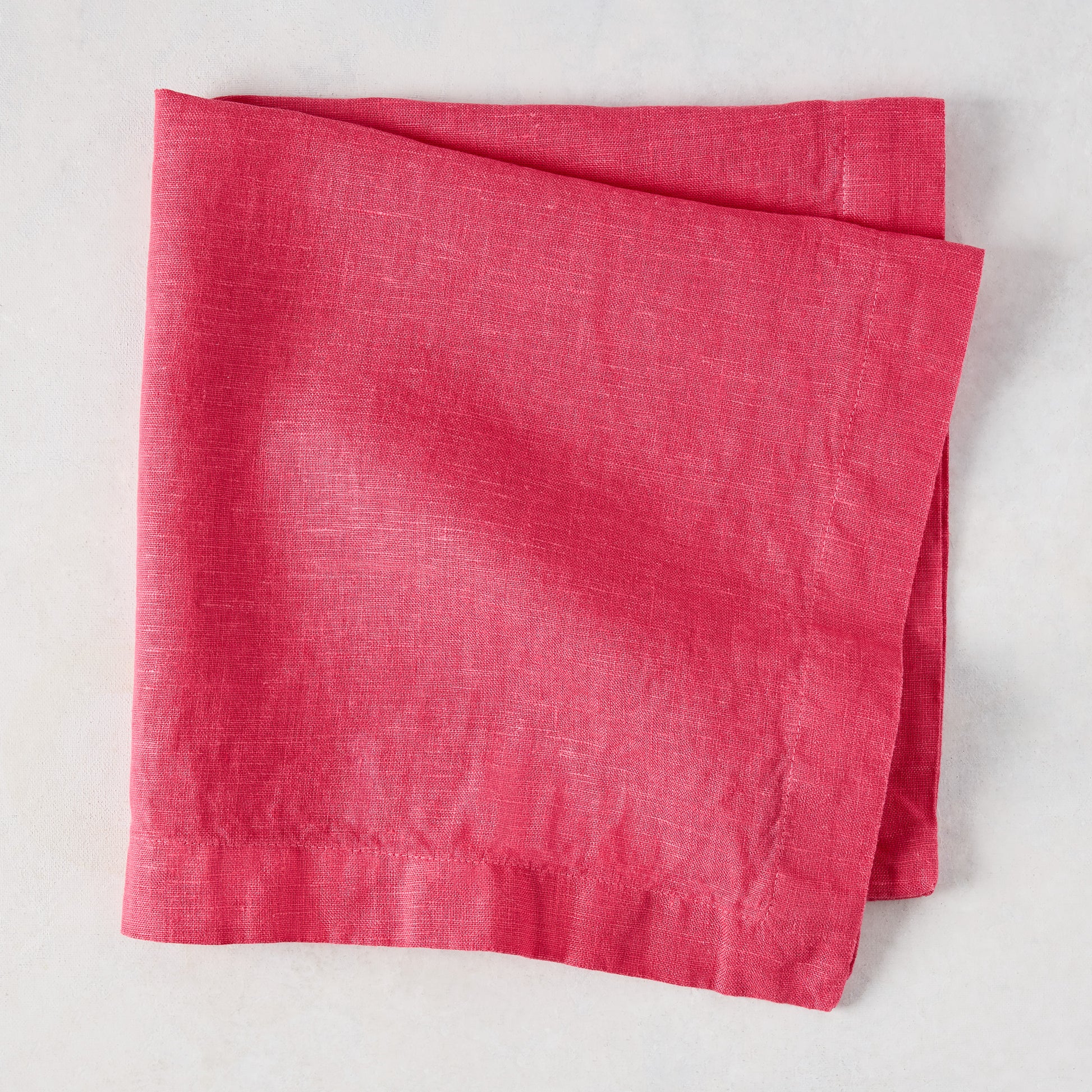 Watermelon HG Signature hand-dyed 22-inch square linen napkin, folded.