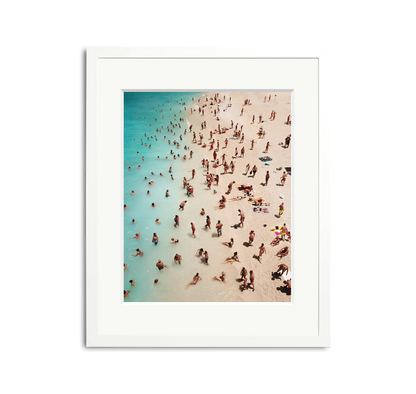 We Forest Framed Wall Art Print: Aerial view of a crowded beach with turquoise water, white sand, and many people, in a white wooden frame with a mat.