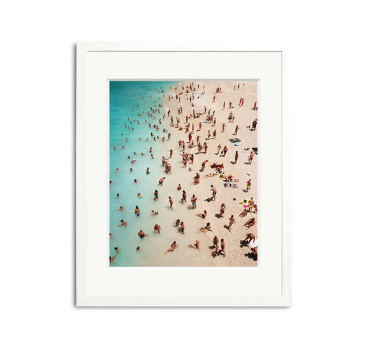 We Forest Framed Wall Art Print: Aerial view of a crowded beach with turquoise water, white sand, and many people, in a white wooden frame with a mat.