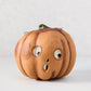 Vintage-style orange papier-mâché pumpkin candy bucket with a distressed finish and surprised face, 7.25 inches tall.