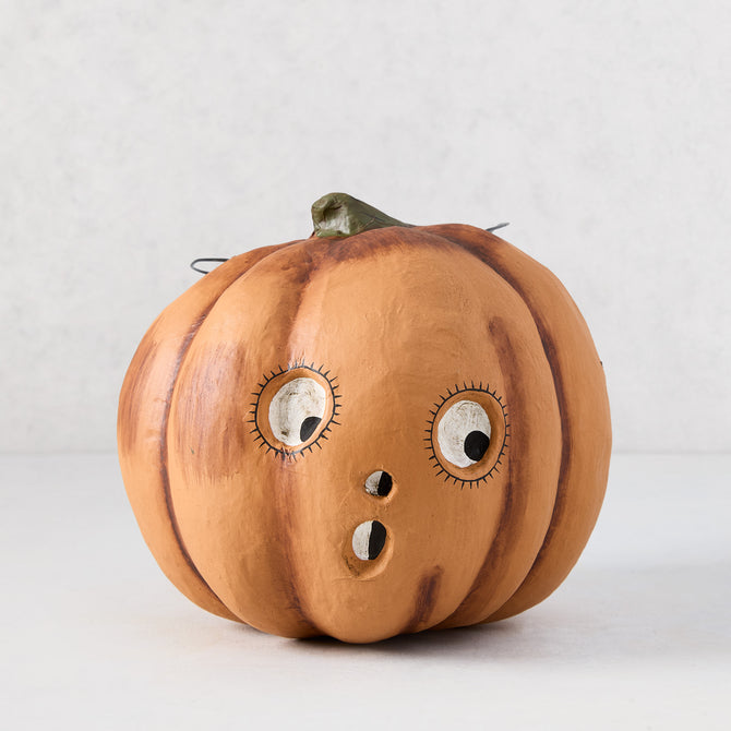 Vintage-style orange papier-mâché pumpkin candy bucket with a distressed finish and surprised face, 7.25 inches tall.