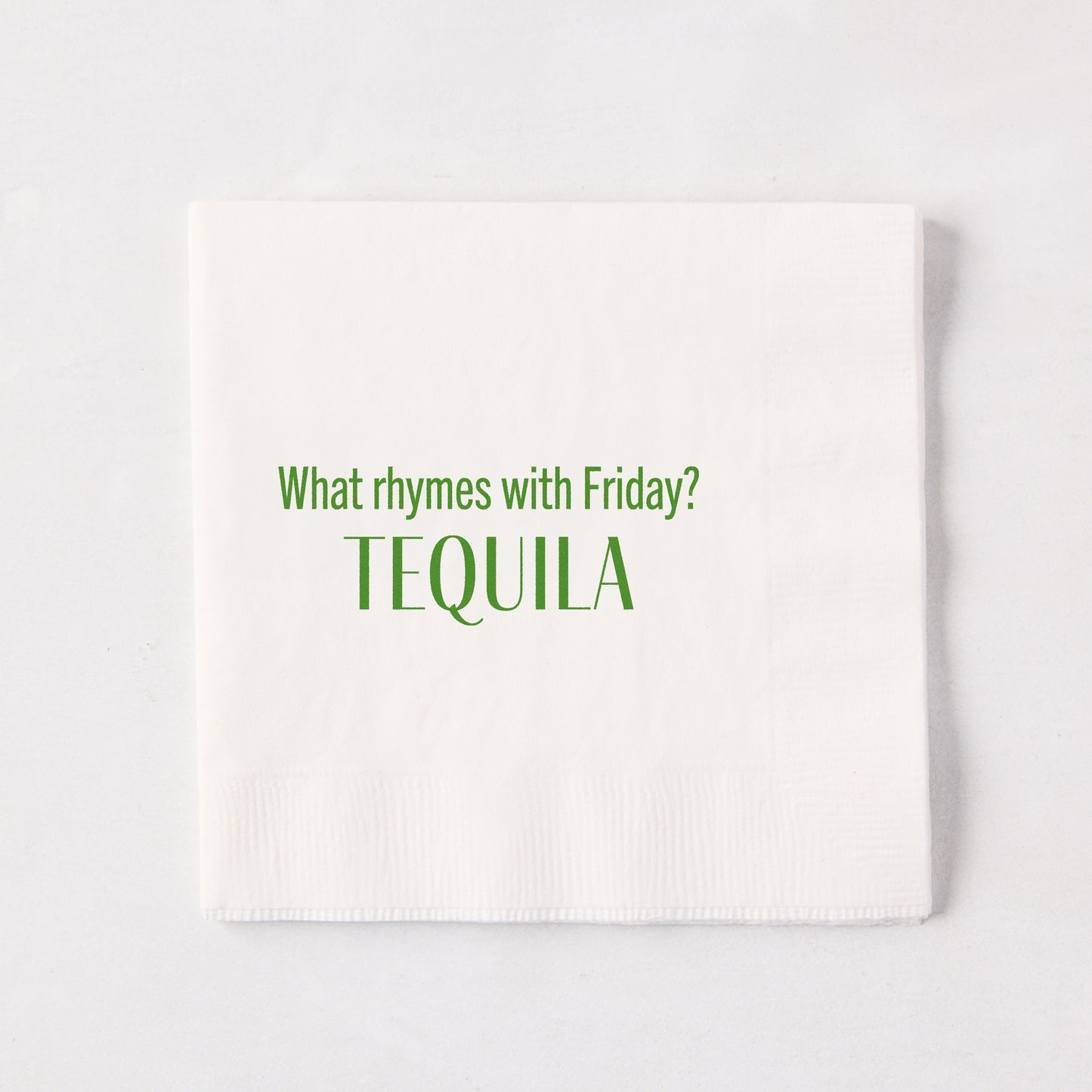 White 5.5" square paper cocktail napkin with "What rhymes with Friday? TEQUILA" in green text.