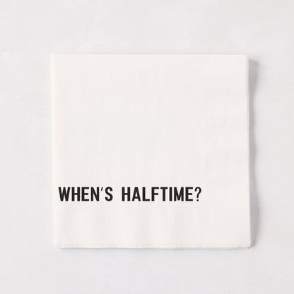 White 5.5" square paper cocktail napkin with "WHEN'S HALFTIME?" in black text.