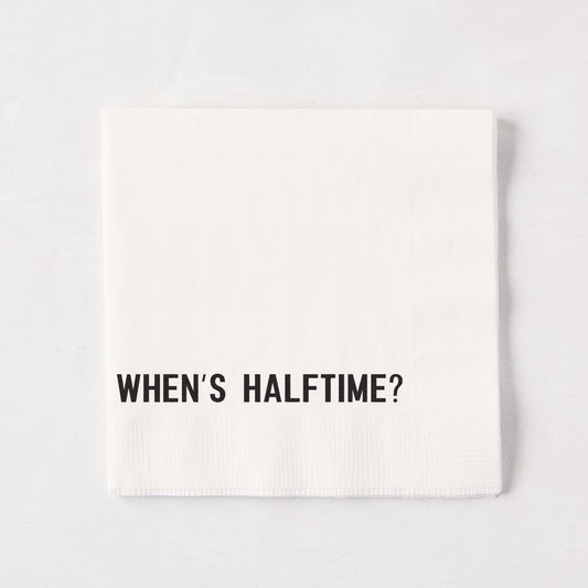 White 5.5" square paper cocktail napkin with "WHEN'S HALFTIME?" in black text.