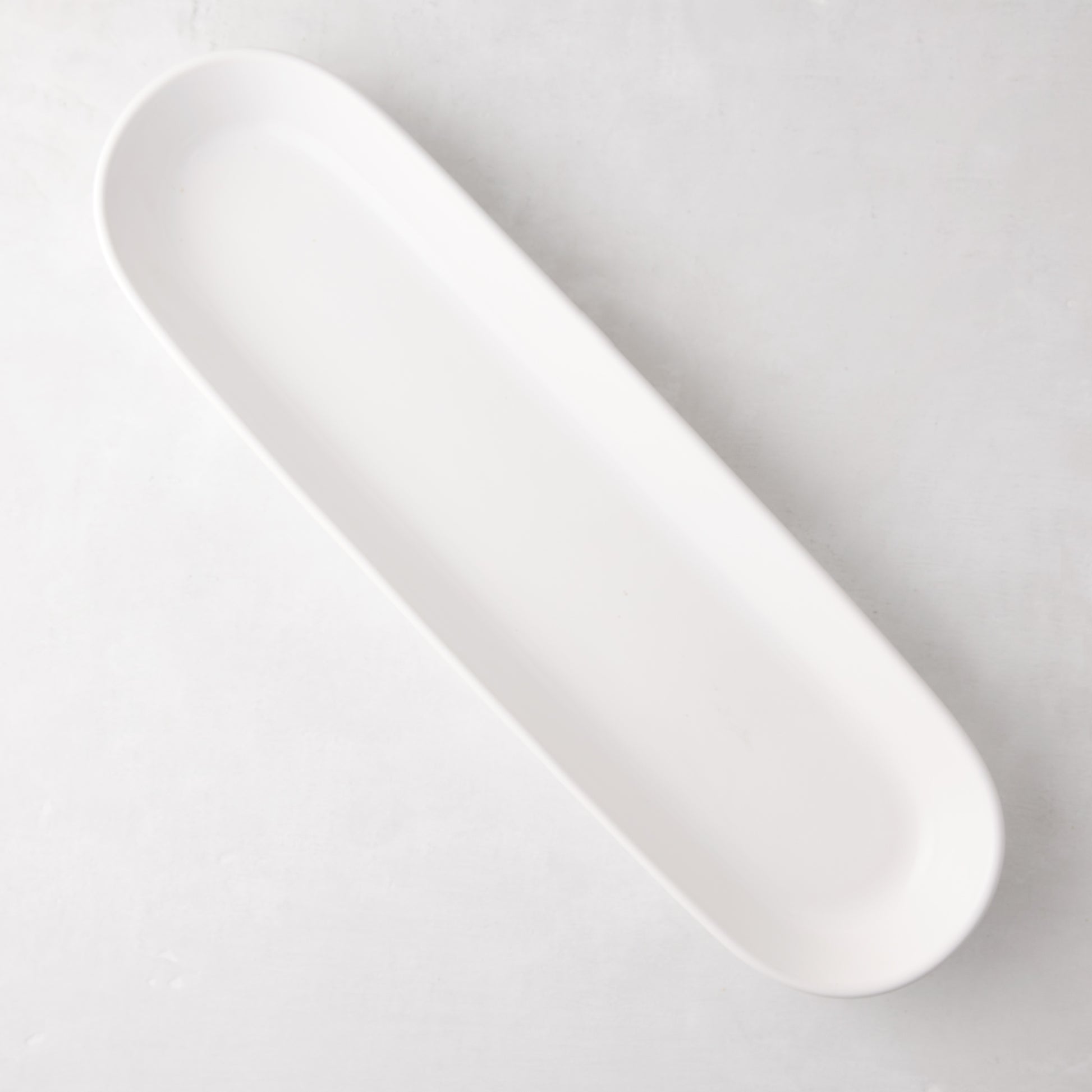 White ceramic narrow oval baguette serving tray, 19.5" long.